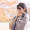 寒さに身をすくめる女性―寒い季節に気をつけたい歯の食いしばりと対策